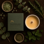 candle box that says EUCALYPTUS  MINT & WILD ROSEMARY with all the botanicals surrounding it and the wooden cross wick candle to the right of the box.