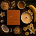 A styled flat-lay of a candle in a white bowl next to its orange box labeled 'TOASTED COCONUT & BANANA NECTAR,' surrounded by coconut pieces, sliced bananas, flowers, and a banana on a dark background.
